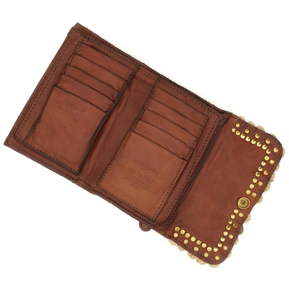 Cartera "MIRTA" con monedero de piel de vacuno teñida en prenda con tachuelas y medallas. Color: Cognac